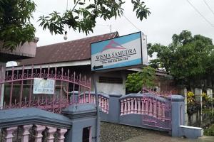 un edificio rosa con un cartel delante en OYO 92002 Wisma Samudra, en Pangkajene