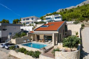 an image of a house with a swimming pool at Villa Oslo - luxury place with sea views & heated pool, 300m far from sandy beach in Omiš