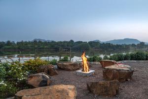 a fire pit in a yard with rocks at SaffronStays Lake House Marigold, Nashik - rustic cottages with private plunge pool in Nashik