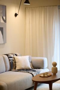 uma sala de estar com um sofá e uma mesa em Mandra Living-Kolonaki em Atenas