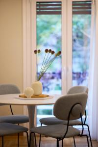 uma mesa com cadeiras e um vaso com flores em Mandra Living-Kolonaki em Atenas