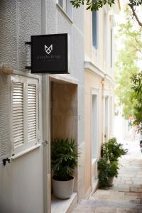 a sign on the side of a building with plants at Phaedrus Living Kolonaki Crown Residences in Athens