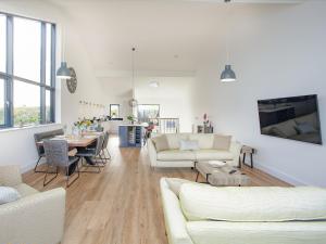 a living room with white furniture and a table at Foxglove-uk34612 in Nether Stowey