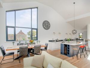 cocina y sala de estar con mesa y sillas en Foxglove-uk34612, en Nether Stowey