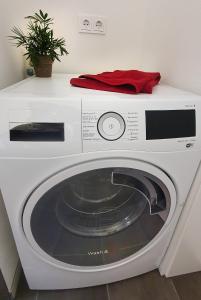 eine weiße Waschmaschine mit einem roten Handtuch darüber in der Unterkunft Donauhosting, Stadt Land Fluss in Unterkirchberg