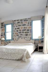 a bedroom with a bed and a brick wall at Mohlos Villas in Mochlos