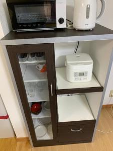 a microwave oven sitting on top of a kitchen shelf at Creative　apartment in Kita-sanjō