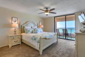 a bedroom with a bed with a ceiling fan and a balcony at 12B Crescent Beach Club in Clearwater Beach