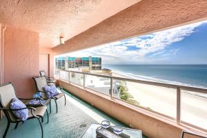 a room with a balcony with a view of the beach at 12B Crescent Beach Club in Clearwater Beach