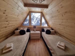 two beds in a tiny house with a window at Apartamenty Termy The Best Bańska in Szaflary