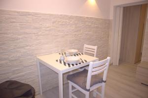 - une table et des chaises blanches dans la chambre dans l'établissement Vittoria Apartment, à Venise