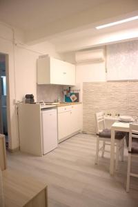 a kitchen with white cabinets and a table and a table and chairs at Vittoria Apartment in Venice