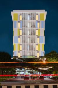 un edificio blanco alto con cuadros coloridos. en Hotel Citradream Cirebon, en Cirebon