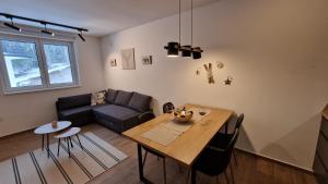 uma sala de estar com uma mesa e um sofá em Xenia Apartment em Kopaonik