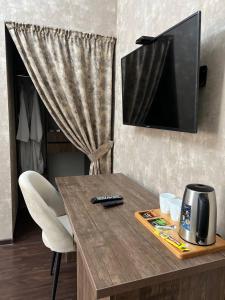 a wooden table with a television on top of it at Grand SPA Hotel in Kostanay
