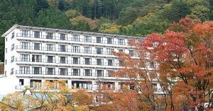 那須鹽原的住宿－Nasushiobara Ichimantei，山前有树木的白色建筑