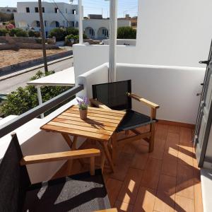 a wooden table and a chair on a balcony at Villa Del Mar in Antiparos