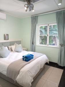 a bedroom with a bed with a blue suitcase on it at Caribbean Estates Private Villas in Port Edward