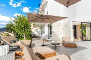 Avitan Premium & Luxury Villas في أديخي: فيلا مطلة على الفناء مع مظلة