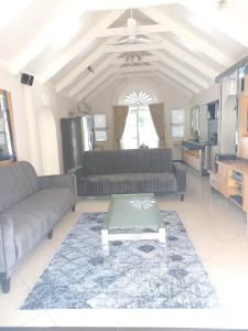 a living room with two couches and a table at Caribbean Estates Private Villas in Port Edward