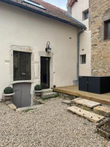 een wit huis met een veranda en een houten terras bij Maison Meursault parking fermé in Meursault