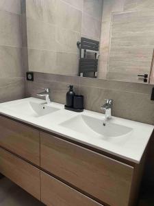La salle de bains est pourvue d'un lavabo blanc et d'un miroir. dans l'établissement Maison Meursault parking fermé, à Meursault