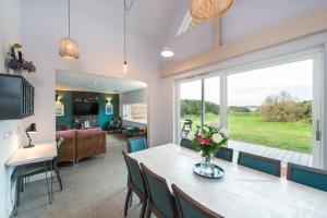 a dining room and living room with a table and chairs at Lodges at Whitekirk Hill some with Hot Tubs - North Berwick in Whitekirk