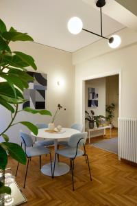 uma sala de jantar com uma mesa branca e cadeiras em Mandra Living-Kolonaki em Atenas