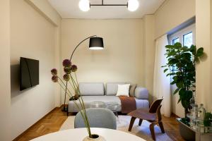 uma sala de estar com um sofá e uma mesa em Mandra Living-Kolonaki em Atenas