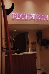 a restaurant with a neon sign on the wall at Rose Thé in La Ciotat