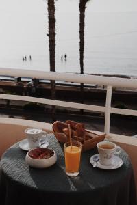 a table with a tray of food and two cups of coffee at Le Rose Thé in La Ciotat