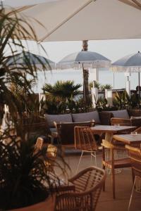 an outdoor restaurant with tables and chairs and umbrellas at Le Rose Thé in La Ciotat