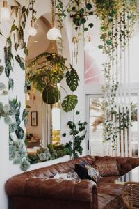 a living room with a couch and lots of plants at Le Rose Thé in La Ciotat