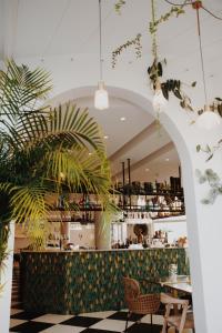 a restaurant with a bar with potted plants at Le Rose Thé in La Ciotat