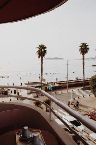 a view of a beach with palm trees and people at Le Rose Thé in La Ciotat