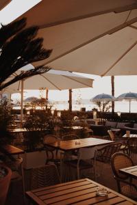 a restaurant with tables and chairs and umbrellas at Le Rose Thé in La Ciotat