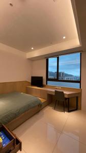 una camera da letto con scrivania, letto e finestra di J-Double Room Xinzhuang District a Xinzhuang