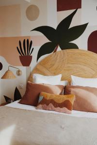 a bedroom with a large wooden bed with pillows at Le Rose Thé in La Ciotat
