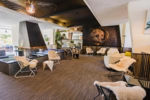 a living room with chairs and a lion on the wall at Hôtel-Résidence Le Lys in Cauterets