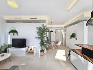 a living room with a white couch and a tv at Beachfront Luxury Apartments by NRAS in Arenales del Sol