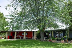 ein rotes Haus mit einem Baum im Hof in der Unterkunft Marculem Guest Farm in Virginia