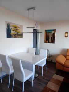 comedor con mesa blanca y sillas blancas en Ferien-Appartement Vier Jahreszeiten, en Freyung