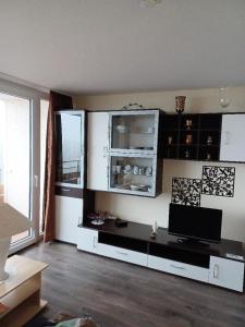 sala de estar con TV y escritorio en Ferien-Appartement Vier Jahreszeiten, en Freyung