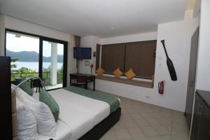ein Hotelzimmer mit einem Bett und Blick auf das Wasser in der Unterkunft Busuanga Bay Lodge in Busuanga