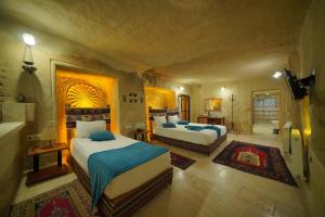 a bedroom with two beds in a room at Fosil Cave Hotel in Ortahisar