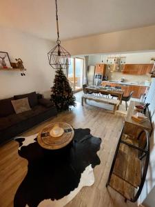 ein Wohnzimmer mit einem Tisch und einem Weihnachtsbaum in der Unterkunft Apartmán MATEO Donovaly in Donovaly