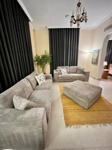 un soggiorno con 2 divani e un lampadario a braccio di Independent Spacious 3 Bedroom Villa a Dubai