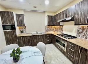 a kitchen with wooden cabinets and a table and a sink at Independent Spacious 3 Bedroom Villa in Dubai