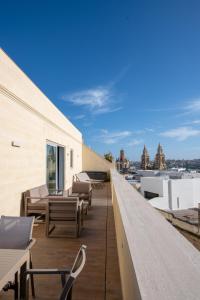 a balcony with tables and chairs on a building at Marea Boutique Hotels in Sliema