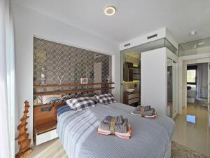 a bedroom with a large bed with two towels on it at Beachfront Luxury Apartments by NRAS in Arenales del Sol